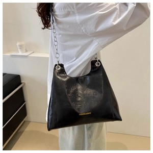 Dettaglio della borsa in pelle nera lucida con catena d'argento e stampa logo sottile