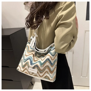 Close-up of zigzag wave pattern woven fabric and white leather trim on shoulder bag
