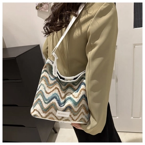 Detail of colorful knitted bucket bag with zigzag pattern and MS.HUIXIBAG brand label