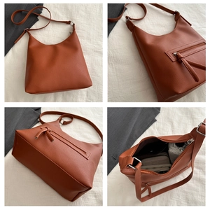 Detail view of cognac pebble leather tote bag showing spacious interior and zip pocket