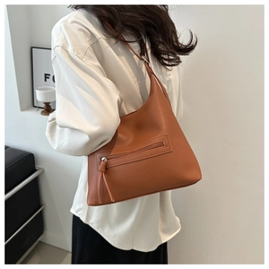 Detailed view of brown lychee grain leather hobo bag with zipper on a shoulder strap