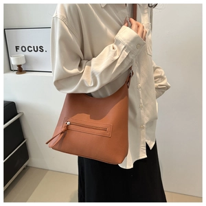 Brown lychee leather tote bag featuring a front zip pocket with stylish long tassels