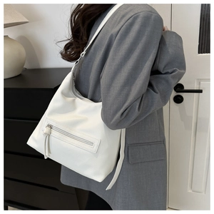 Detailed close-up of a white tote bag with lychee grain texture and front zipper pocket