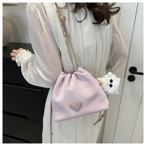 Detail der rosa Kordelzug-Beuteltasche mit Goldkette und Plüschbär-Anhänger-Dekoration