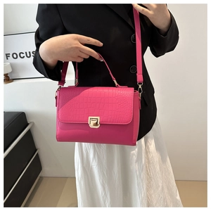 Détail du sac carré rose fuchsia avec motif crocodile embossé et boucle dorée