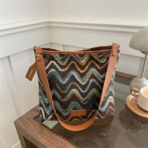 Brown and blue wavy knit bucket bag with leather strap and spacious interior