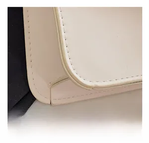 Detail shot of precise stitching and premium cream leather finish on the crossbody bag