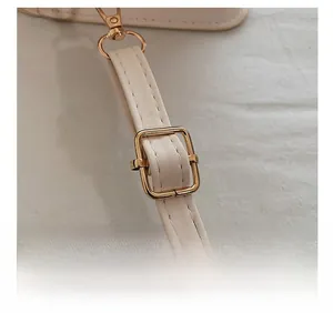 Detail view of adjustable beige PU leather strap with golden metal buckle and lobster clasp