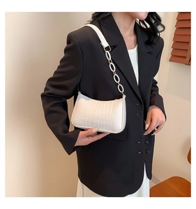 White faux crocodile skin texture and chain strap detail on a stylish underarm bag