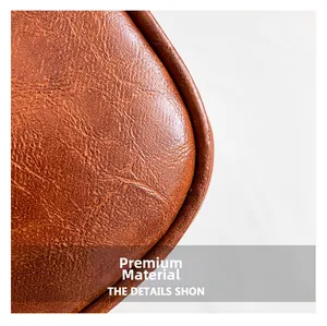 Gros plan sur la texture du cuir synthétique marron et les coutures de la sacoche