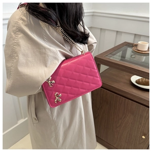 Quilted pink crossbody bag with golden butterfly charms and chain strap detail