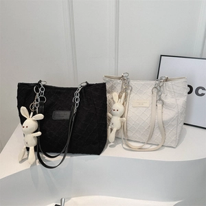 Chic textured tote bags in black and beige with chain straps and plush bunny charms