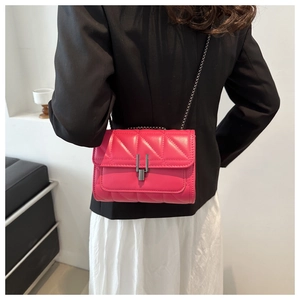 Detailansicht der pinkfarbenen Stepptasche mit Kette und Metallverschluss an der Taille