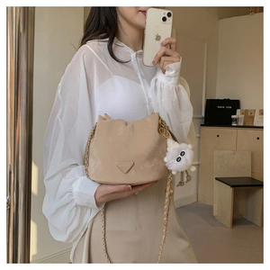 Détail du sac seau beige en daim avec bandoulière chaîne et breloque peluche