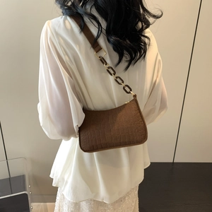 Brown crocodile embossed shoulder bag with stylish acrylic chain strap on model back