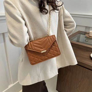 Elegant caramel leather crossbody bag with V-shaped stitching and gold chain strap