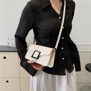 Chic beige crossbody square bag with a prominent black buckle on a textured PU leather flap