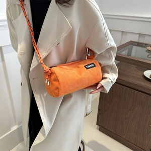 Fashionable bright orange corduroy cylinder crossbody bag with woven rope shoulder strap