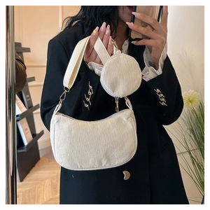 Detail view of corduroy crescent bag set with round pouch in creamy white color