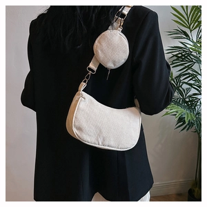 Detailed texture of white corduroy crescent bag and small round coin purse on shoulder