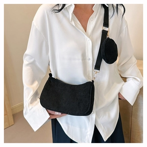 Detail of black corduroy two-in-one crossbody bag featuring a round coin purse attachment