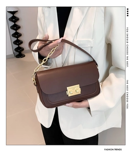 Brown leather shoulder bag featuring a classic flap design and gold square metal clasp