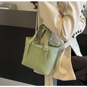 Styling of a sage green leather crossbody bag paired with an elegant beige blazer suit