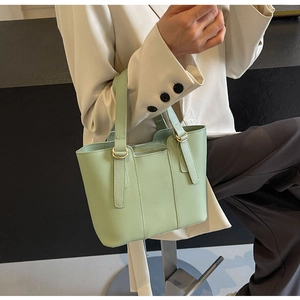 Detail view of mint green tote bag with premium leather texture and gold metal ring handles