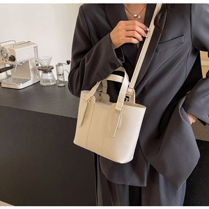 Détail d'un sac cabas crème sur mannequin avec fermoir doré et coutures fines