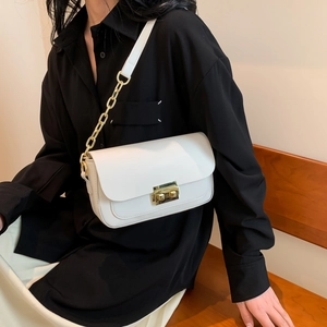 Stylish white matte leather crossbody bag with gold buckle on a black shirt outfit