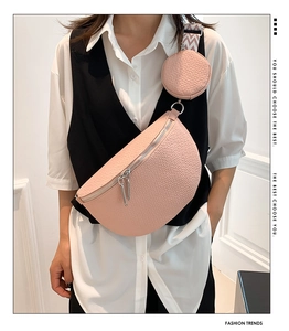 Macro detail of pink pebble leather chest bag with silver zippers and mini coin pouch