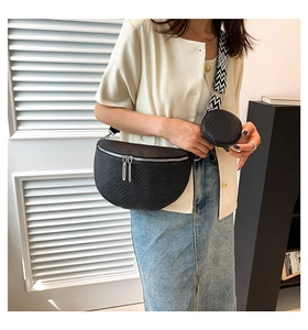 Detail of black lychee texture crossbody bag with geometric strap and round coin purse