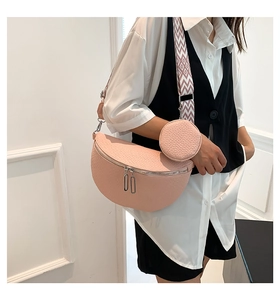 Pink lychee leather crossbody bag with dual zippers and geometric strap shown on model