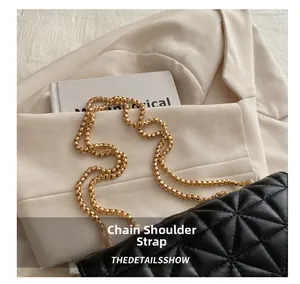 Detalle de la correa de cadena dorada en bolso bandolera acolchado negro de moda