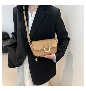 Borsa color kaki con stampa coccodrillo e fibbia dorata indossata da modella in blazer