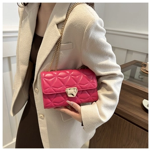 Detailed close-up of rose red quilted chain bag with elegant gold geometric metal lock