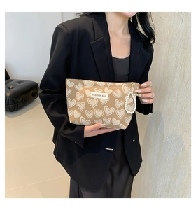 Detail of trendy mini phone bag with heart print and decorative pearl chain handle