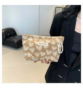 Detail of khaki heart print phone bag featuring pearl charm and Fashion Bag label