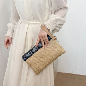 Ethnic straw clutch bag with blue floral fabric trim and wristlet for summer beach fashion