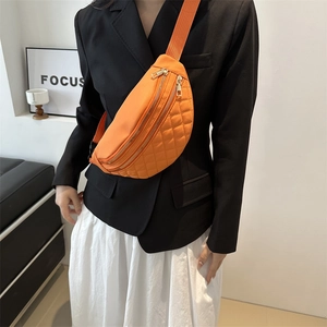 Bright orange quilted fanny pack with gold zippers shown on a fashion model