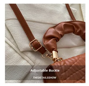 Detail of crocodile embossed square bag featuring pleated handle and gold adjustable buckle