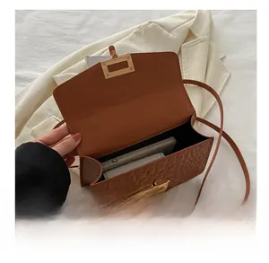 Capacity detail of crocodile pattern square bag showing space for phone and wallet