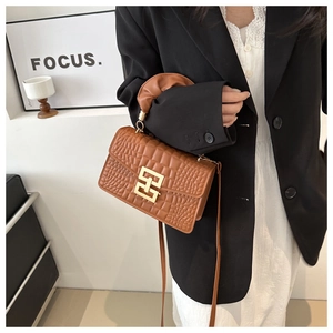 Detail of caramel crocodile embossed handbag with golden geometric lock and ruched handle