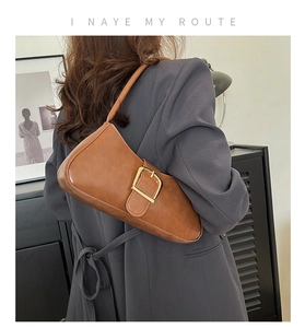 Detail showing the retro brown leather shoulder bag with a square golden buckle buckle