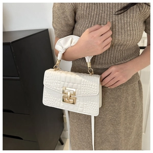 White croc-embossed handbag featuring a gold buckle and stylish ruched handle detail