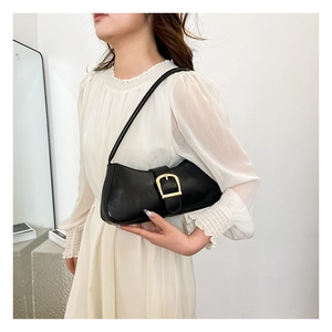 Detailed view of black vintage baguette bag featuring a prominent gold square buckle