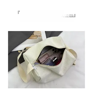Detailed interior storage view of a white corduroy shoulder bag showing daily essentials