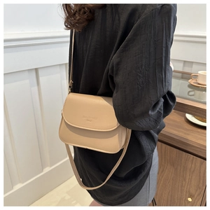 Détail du sac besace beige avec texture en cuir et fine bandoulière élégante