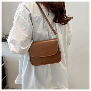 Détail du sac bandoulière marron caramel avec ferrures dorées et finition cuir lisse