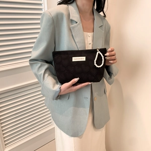 Fashionable black heart-embossed mini phone bag with an elegant white pearl wrist strap